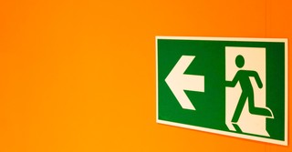 Green exit sign on a yellow background