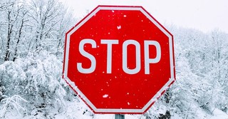 Stop sign in the snow, pride comes before the fall
