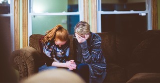 Praying women on a couch