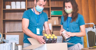 Man and a woman packing food in a food pantry