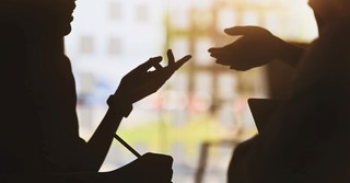 Silhouette of people's hands while they are having a conversation