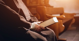 Pastor holding a Bible in a pew