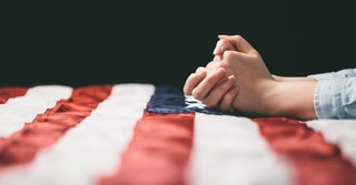a woman praying over an American flag
