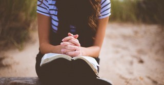 Woman praying on a beach