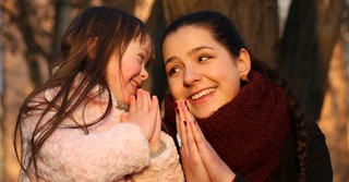 Mom and young daughter praying together