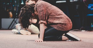 Person kneeling in prayer