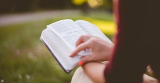 A woman reading the book of Colossians outside