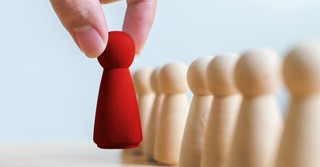 Person choosing a red peg from a line of white pegs