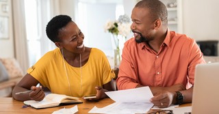 Couple smiling at each other while doing paperwork