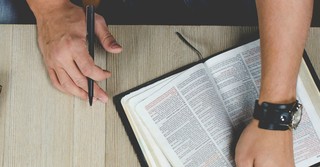 Overhead shot of a man studying from an open Bible