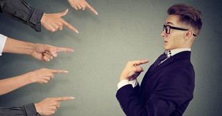 Many fingers pointing at a man, accusing him