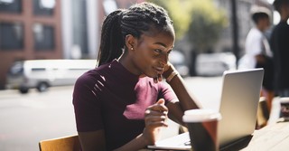 Woman working on a laptop outside