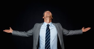 Businessman with arms out, looking up