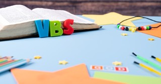 Kids crafts next to a Bible and the letters VBS