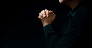 man praying in the dark