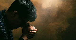 Man with head bowed in prayer