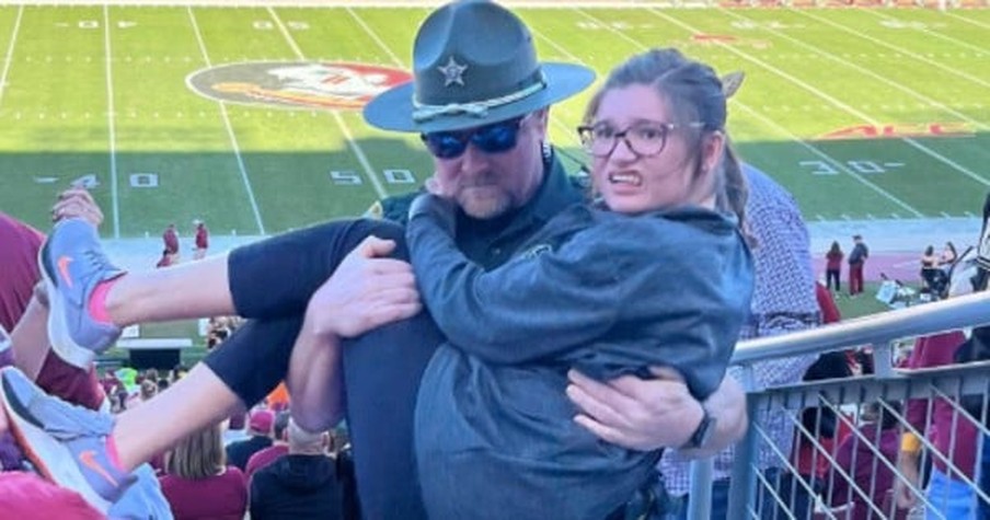 Girl Struggled with Stairs at Football Game and Image of Police Officer Carrying Her Went Viral