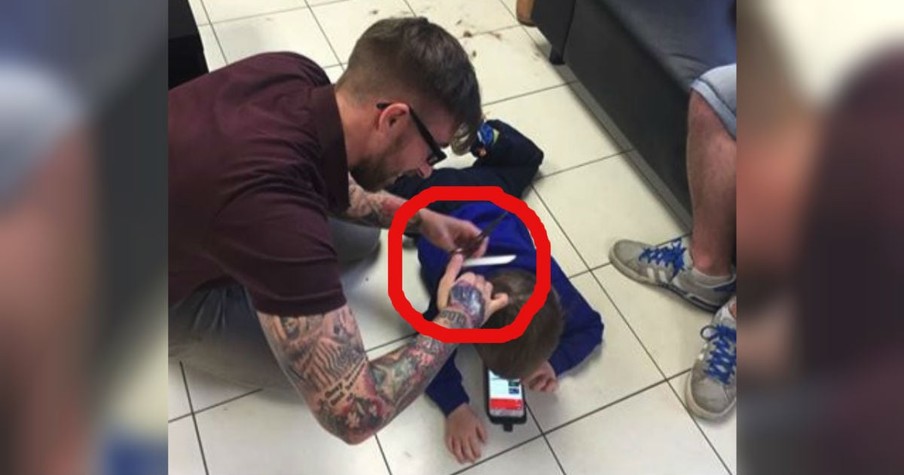 Barber Lays On The Floor For A Boy With Autism's Haircut