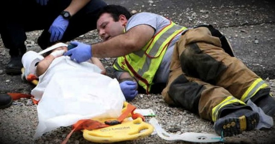 Firefighter Lays On Ground With Terrified Little Boy After Car Accident