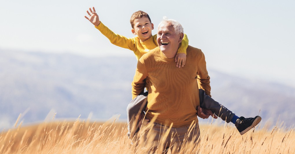 grandparent and kid hiking in a field
