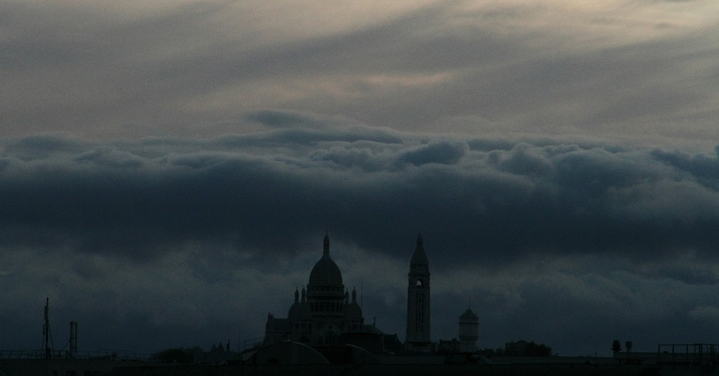 dark skyline with church and bell tower under storm clouds, hymns with messages for christians during times of crisis