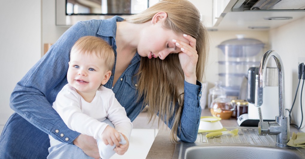stressed mom with child on hip in kitchen