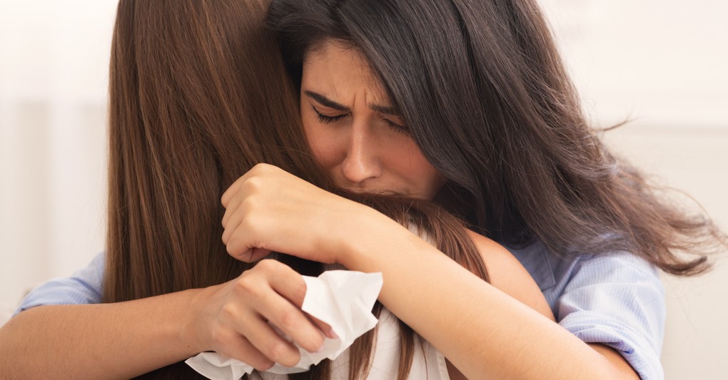 friends hugging while crying