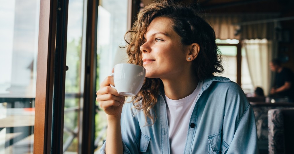 young woman drinking coffee looking outside in cafe restaurant, ways to make your every day more meaningful