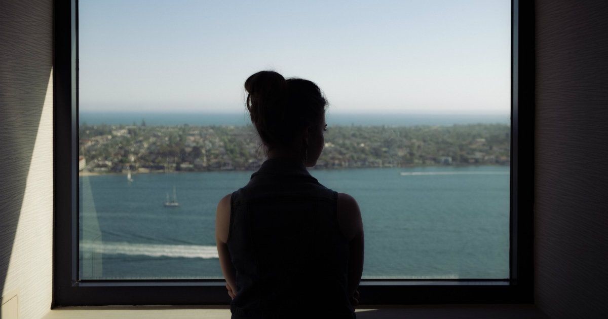 woman silhouetted looking out of window at water, prayers for singles 