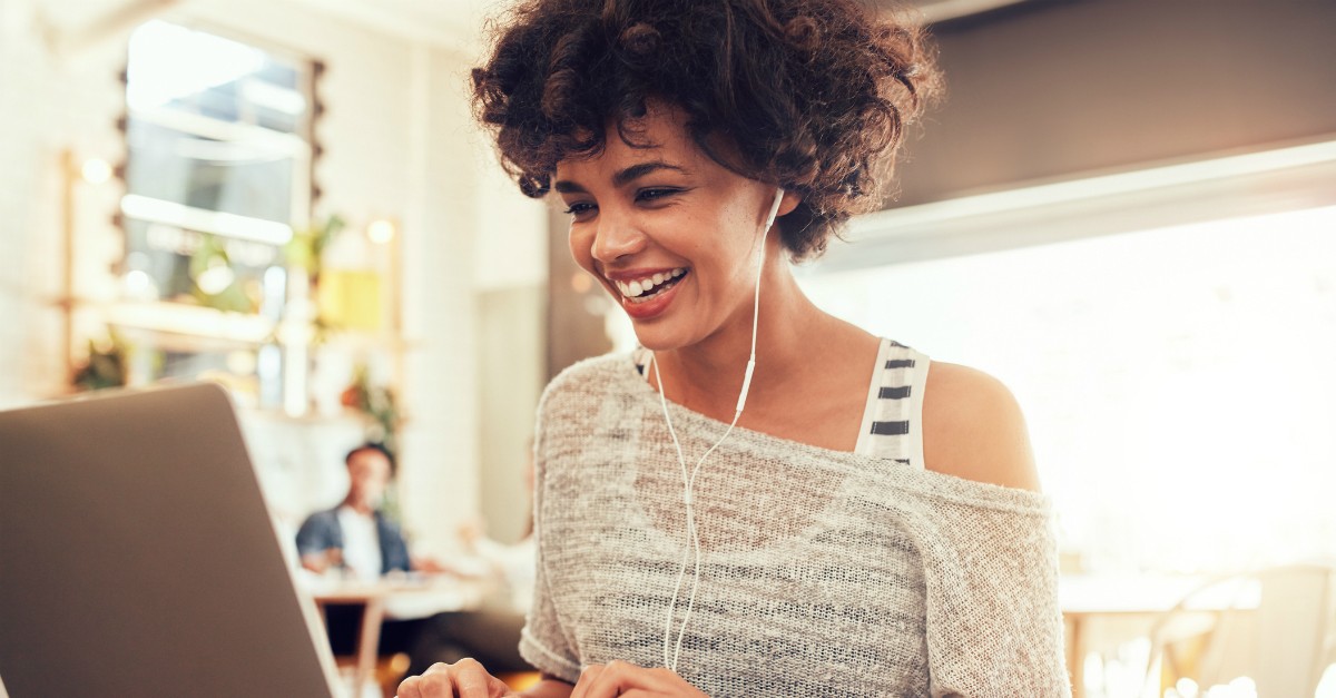girl wearing headphones smiling at computer