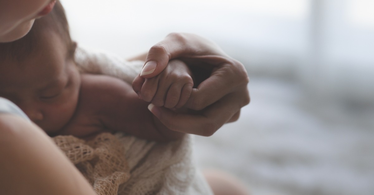 Close up of a mother holding her infant's hand