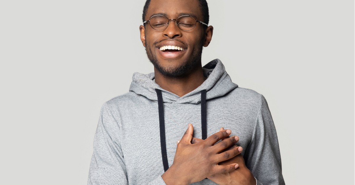 man smiling hands over heart peace and joy
