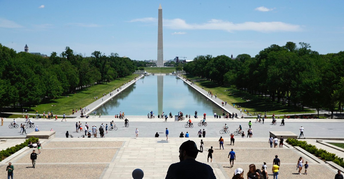 A man sitting in front of the Washington monument, religious liberty means COVID-19 restrictions cannot target churchgoers