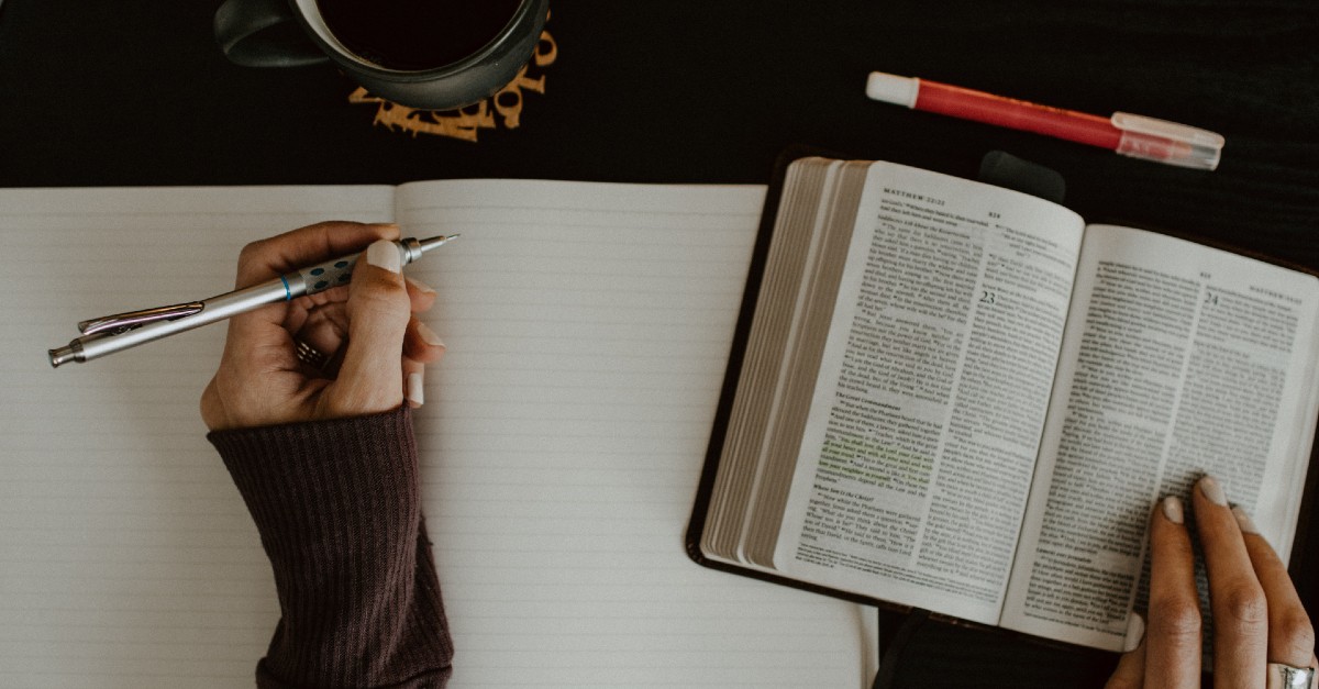 woman reading bible and journaling