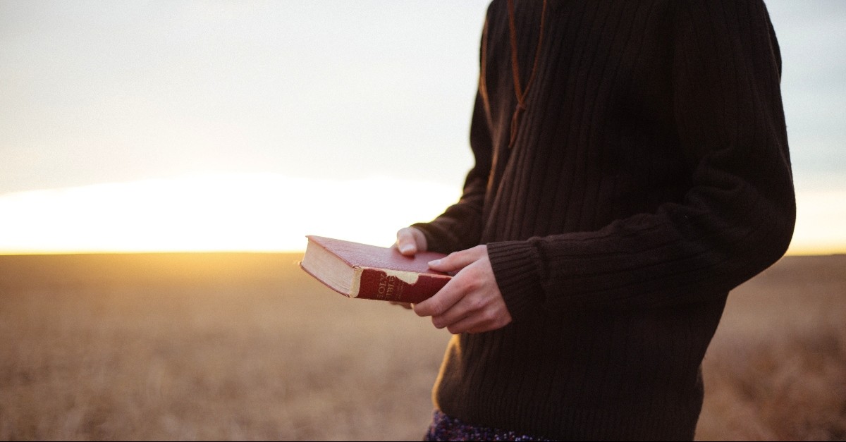 Person standing with the Bible