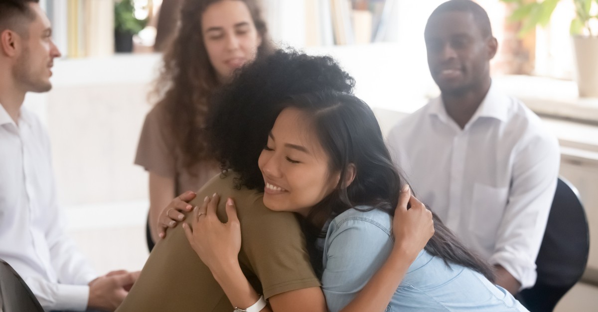 culturally diverse group of adults two hugging