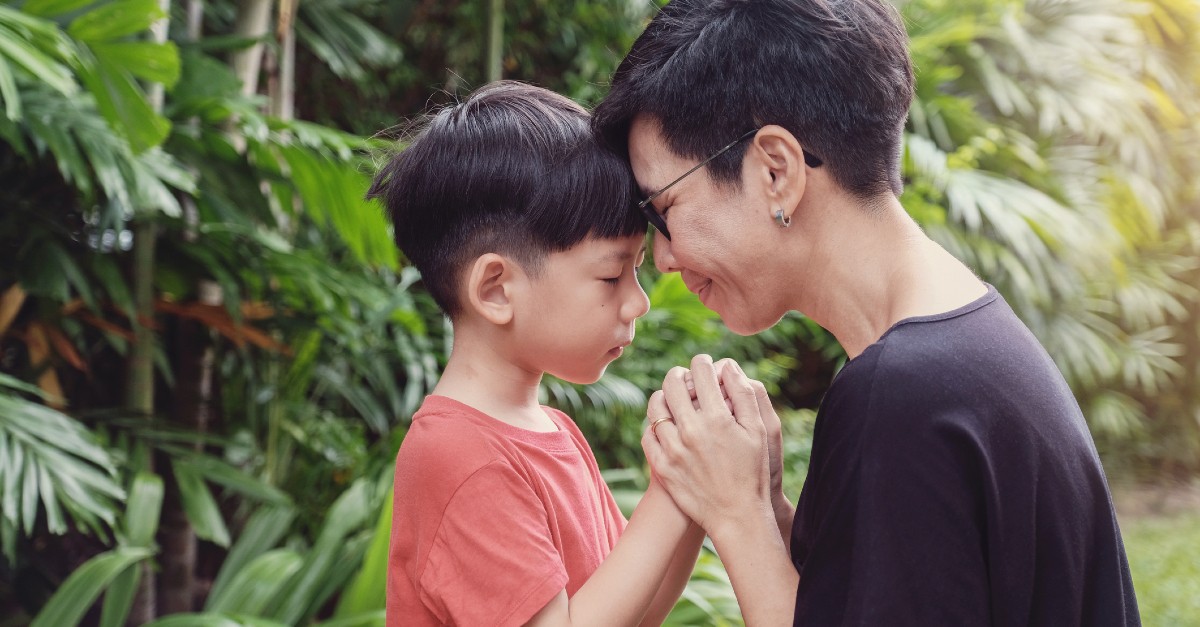 mom praying with kid outside