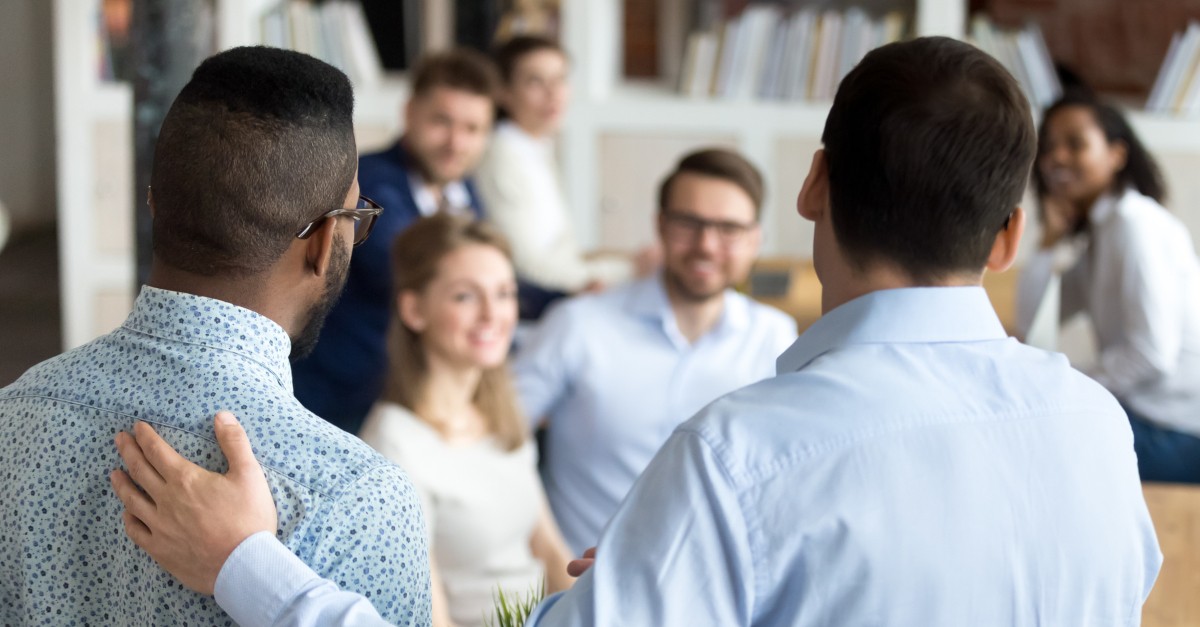 business man thanking praising coworker to group