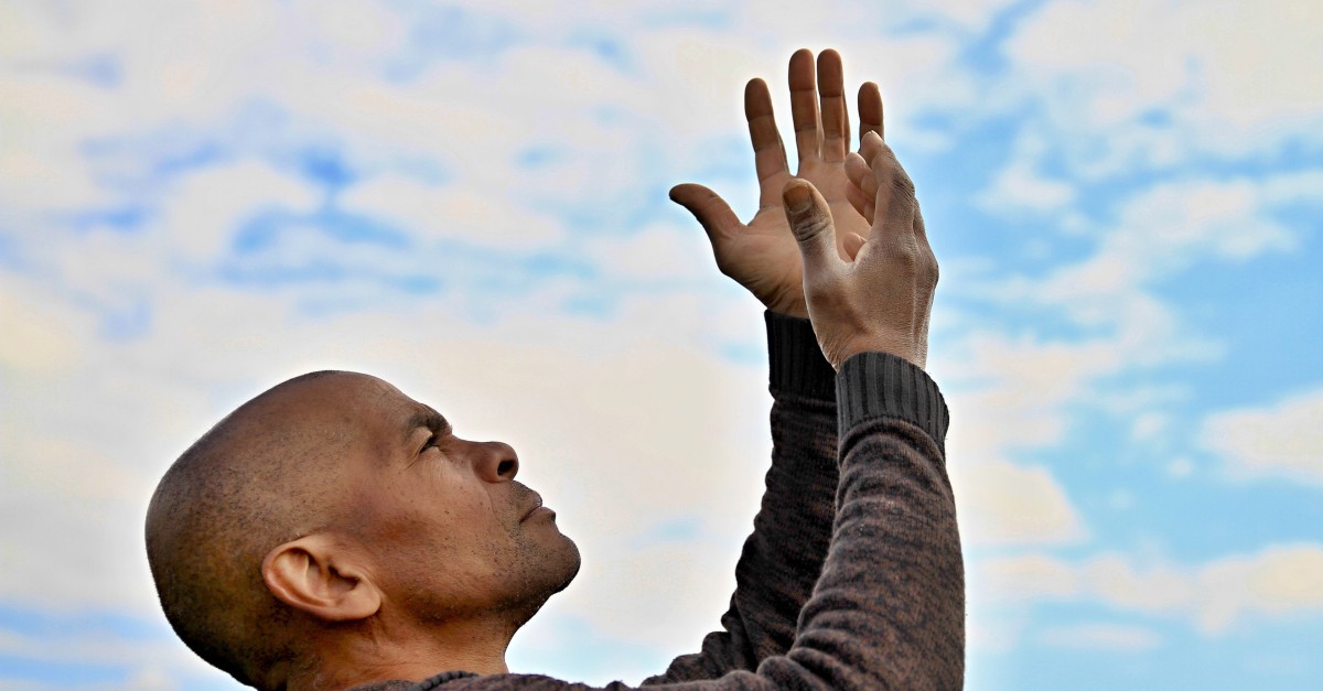 man with arms up to blue sky praise God, you are worthy of it all hymns of praise