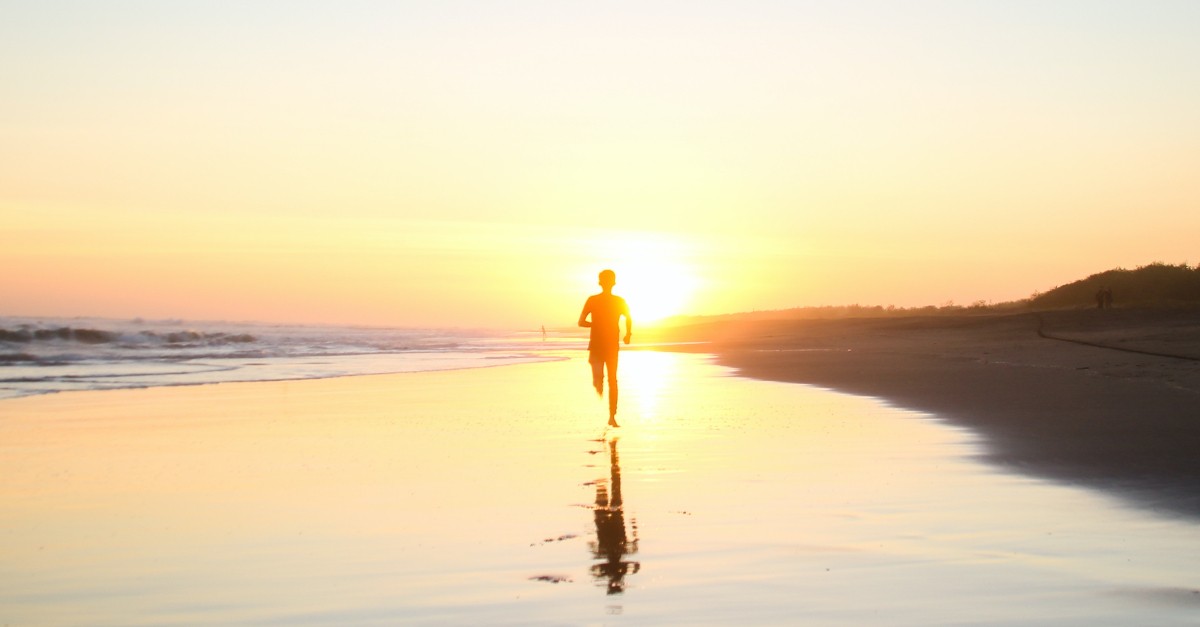 boy running down beach toward sunset at dusk, find relief when hurting