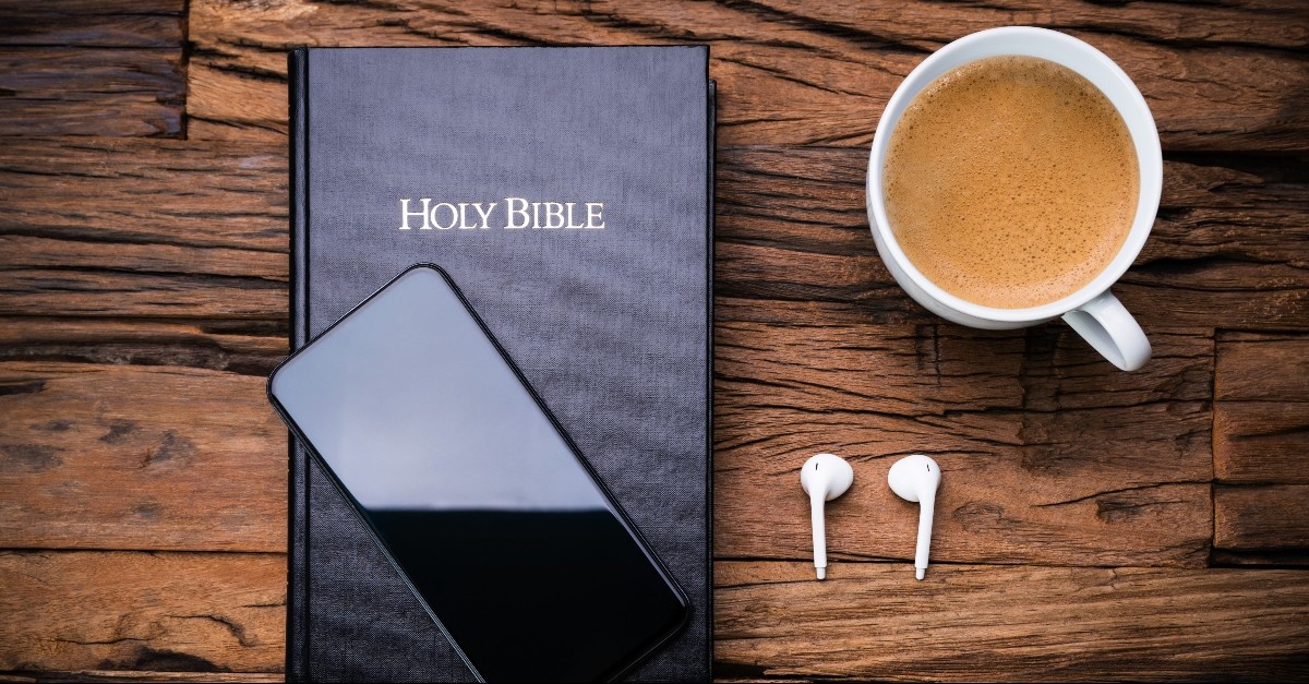 Bible, smart phone, and airpods on a desk