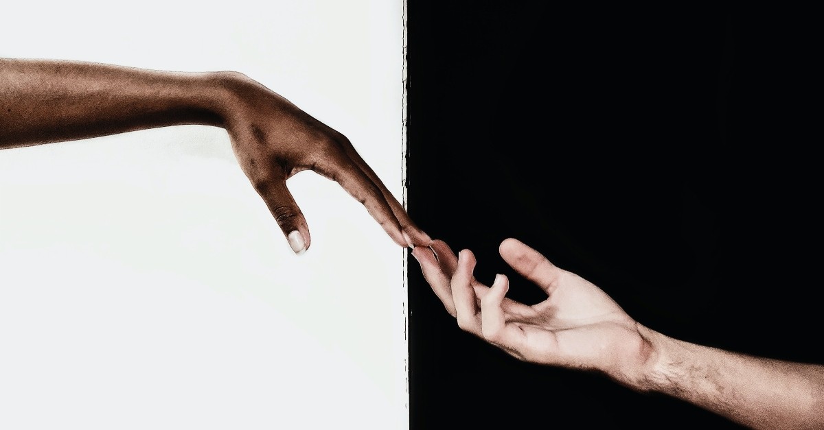 black and white hands reaching out to each other