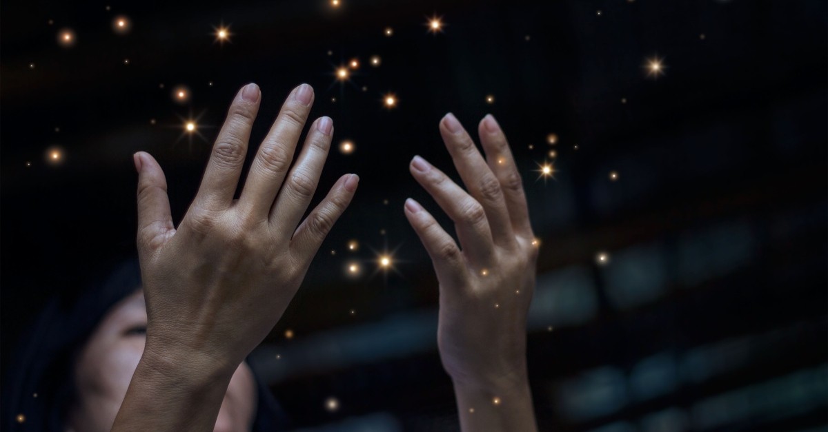 woman hands up in worship little lights sparkling