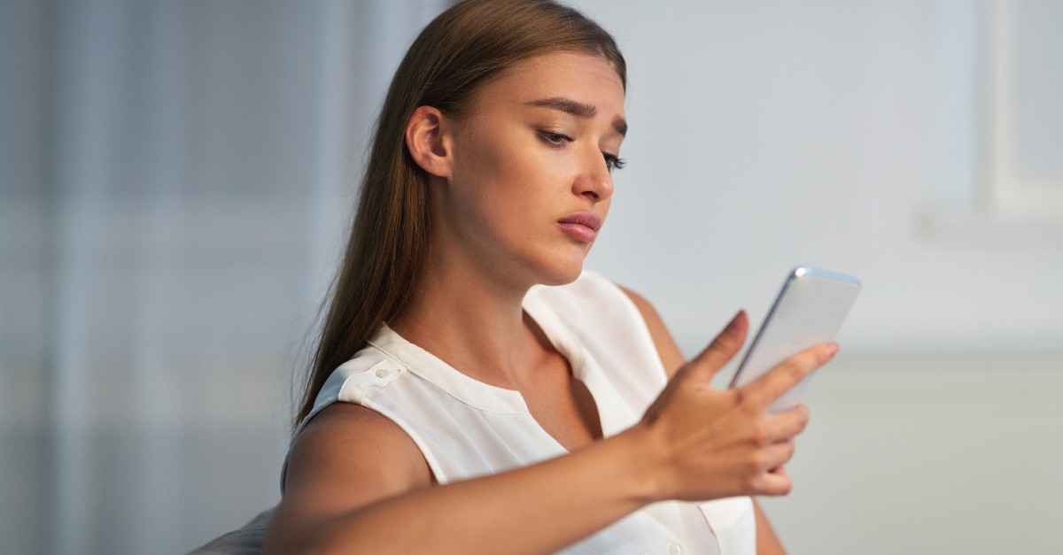 sad woman looking at her phone