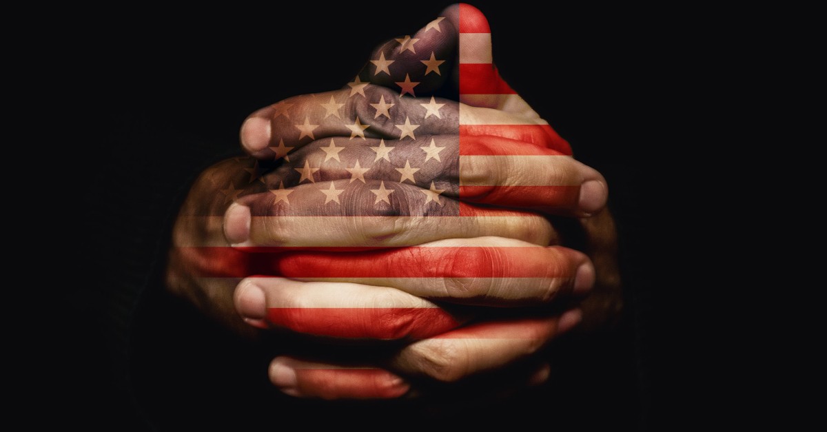 praying hands imprinted with Amerian flag
