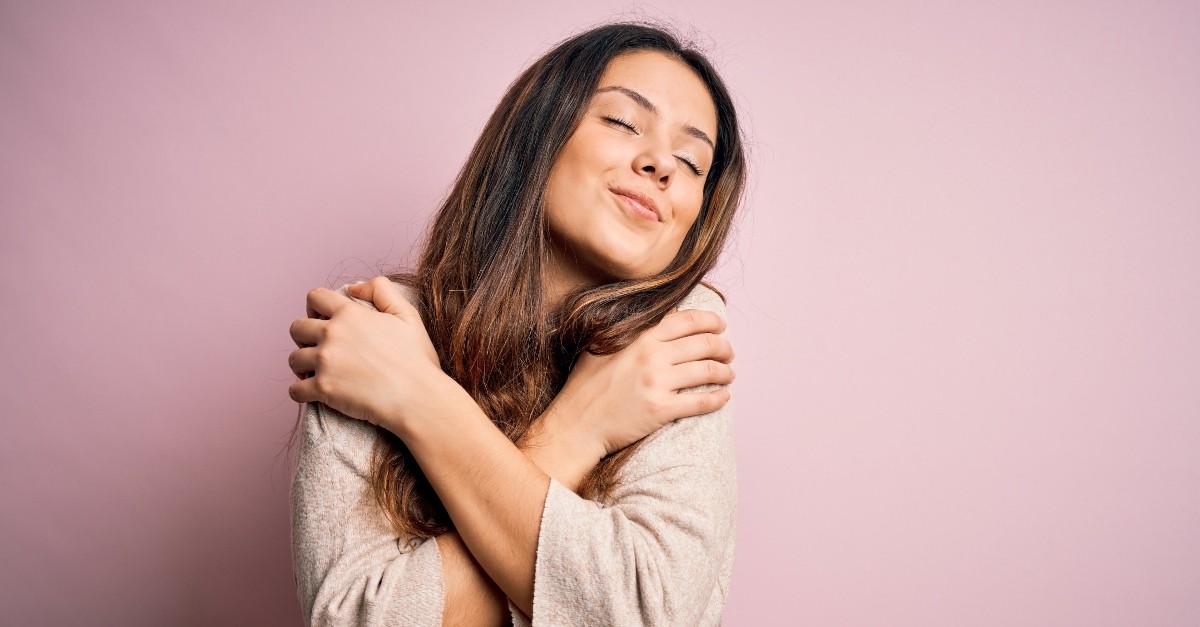 woman hugging herself feeling in love, what the world gets wrong about love
