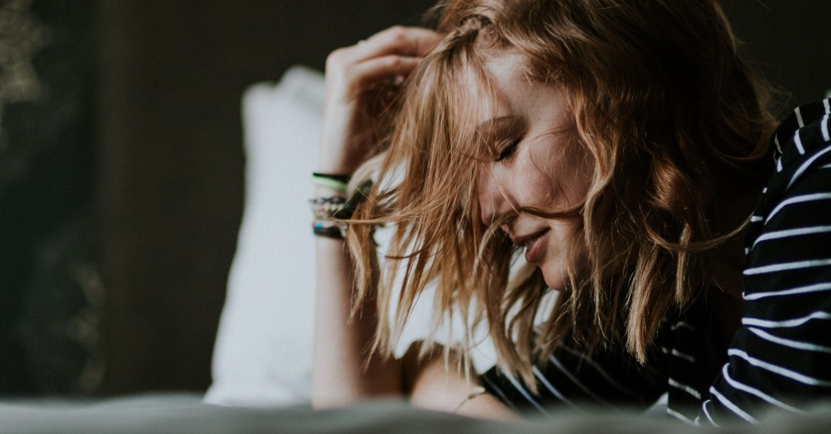 woman with eyes closed thinking and praying for peace and rest, top bible verses to relieve stress