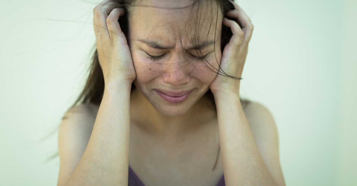woman holding her head looking scared and distressed, how to pray when thoughts out of control