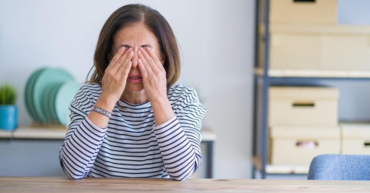 senior woman rubbing eyes looking exhausted