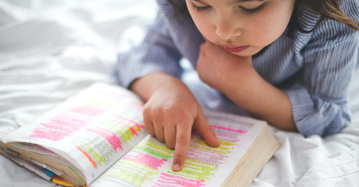 Child reading a highlighted Bible, Bible verses for kids